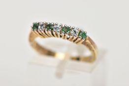 A YELLOW METAL EMERALD AND CUBIC ZIRCONIA HALF HOOP RING, designed with a row of circular cut