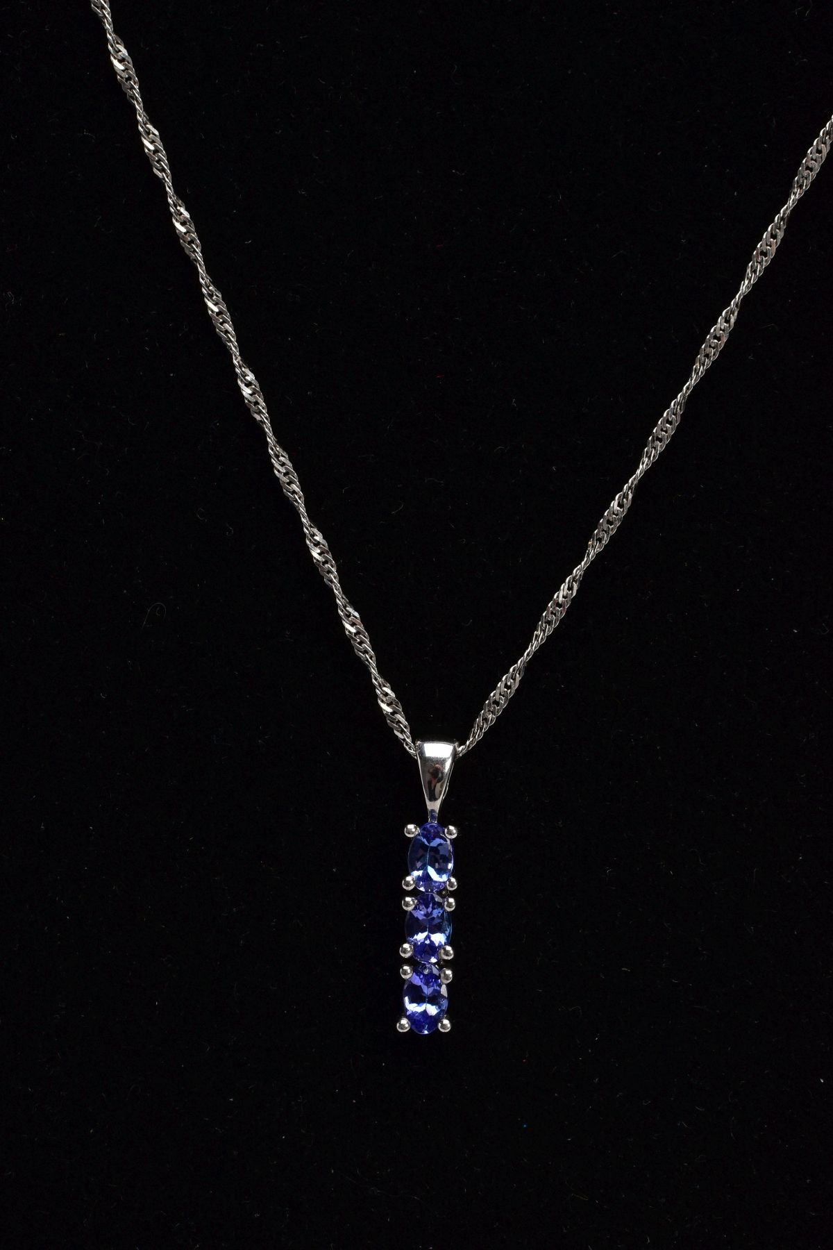 A 9CT WHITE GOLD, TANZANITE PENDANT NECKLACE, the pendant designed with a row of three claw set, - Image 3 of 3