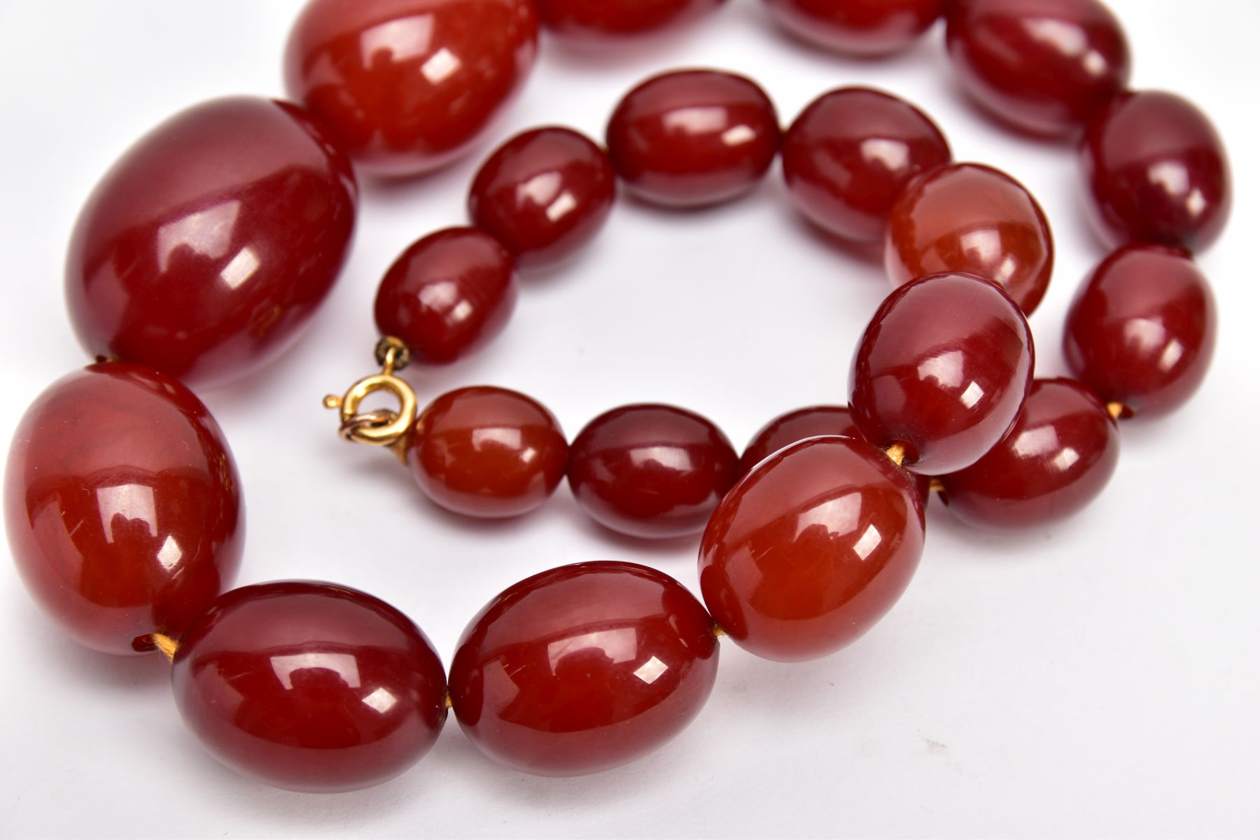 A CHERRY AMBER GRADUATED BEAD NECKLACE, the largest measuring approximately 31.7mm x 23.3mm, the - Image 3 of 4