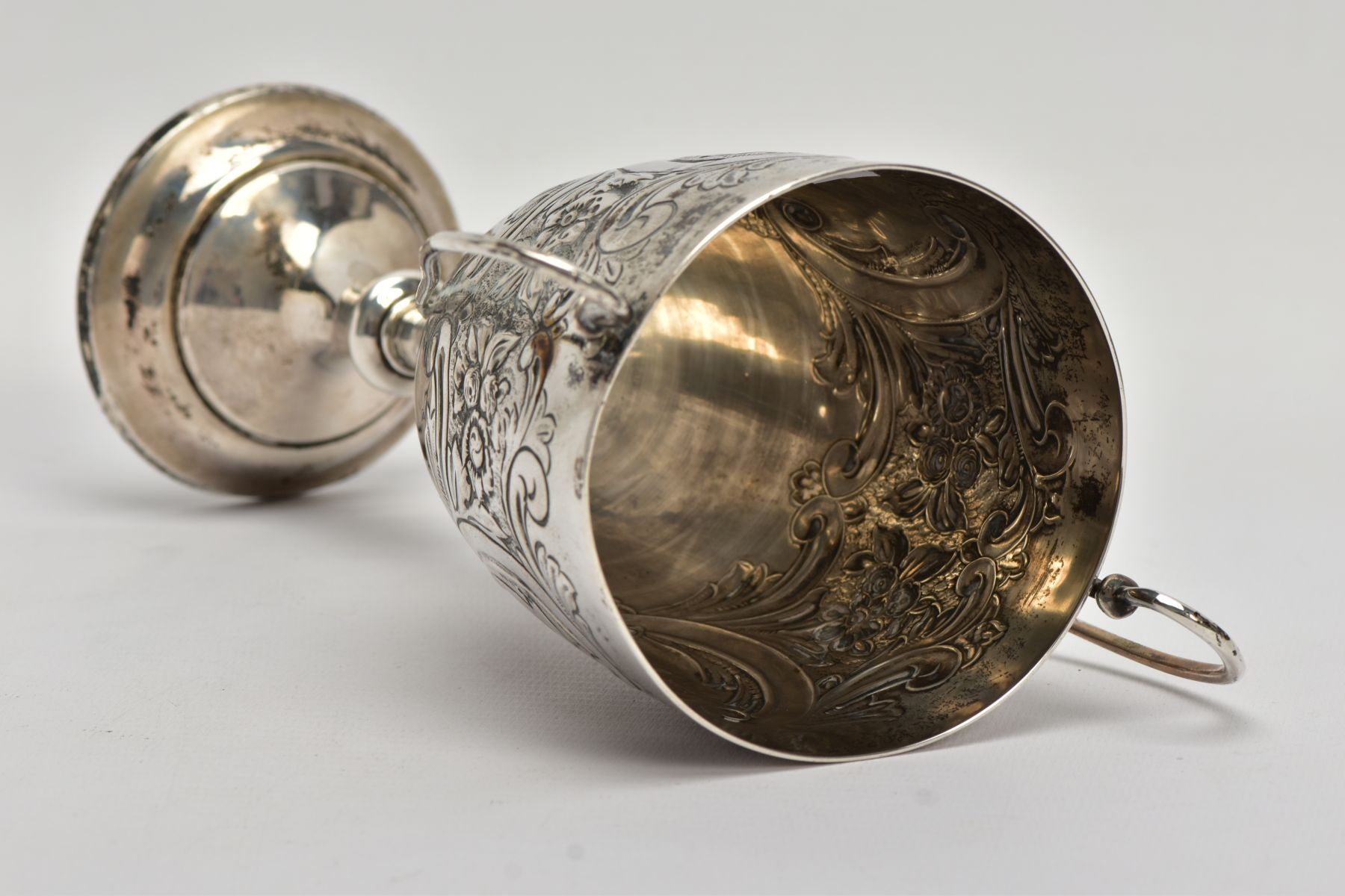 A SILVER TROPHY CUP, double scroll handles, embossed floral and foliate design, with a vacant - Image 6 of 7