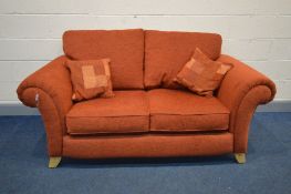 A BURNT ORANGE SETTEE, inner width 120cm, on splayed feet