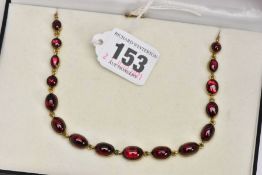 A BASE METAL GARNET STYLE NECKLET, designed with sixteen graduated garnet cabochons, each in