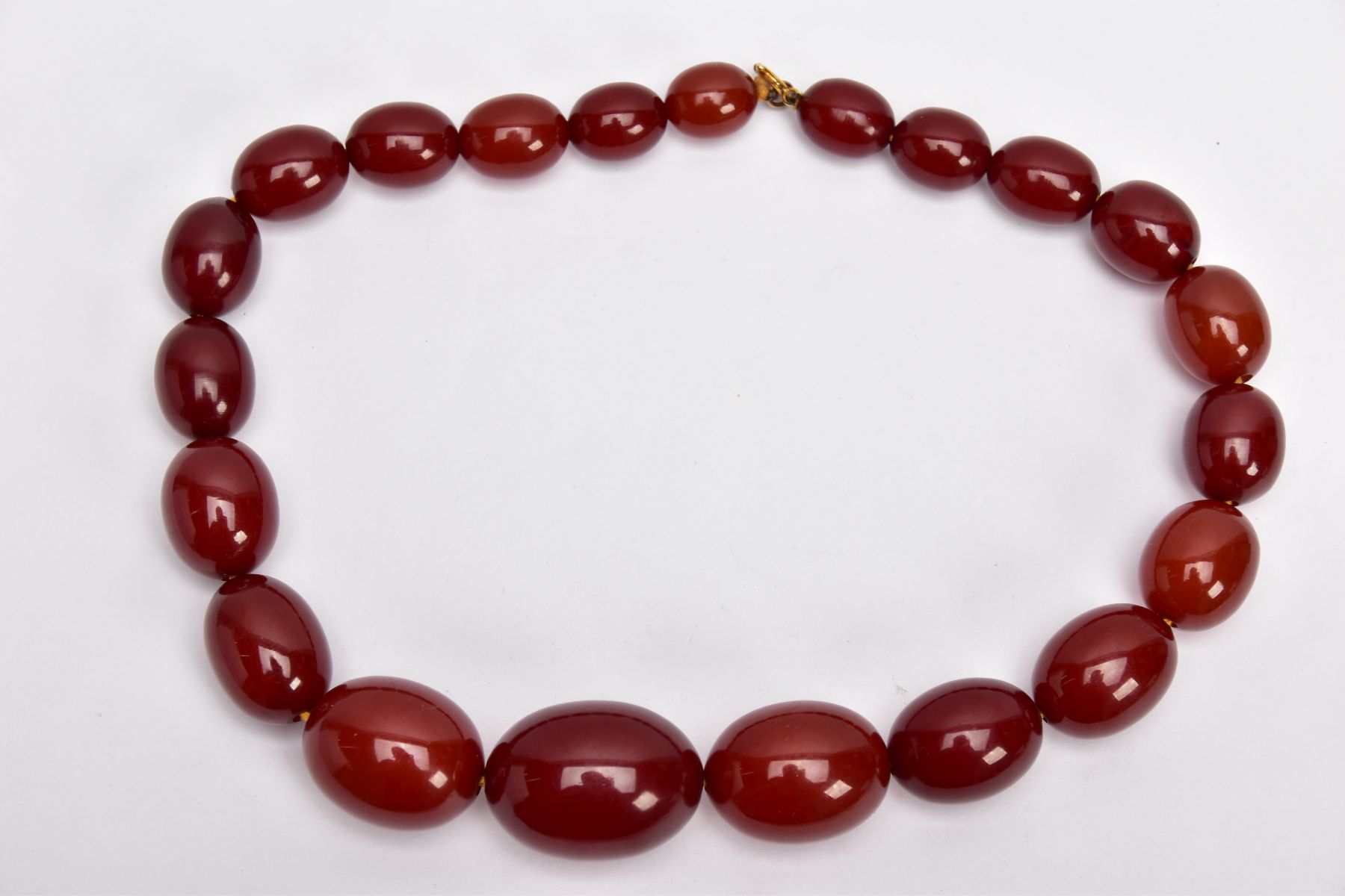 A CHERRY AMBER GRADUATED BEAD NECKLACE, the largest measuring approximately 31.7mm x 23.3mm, the