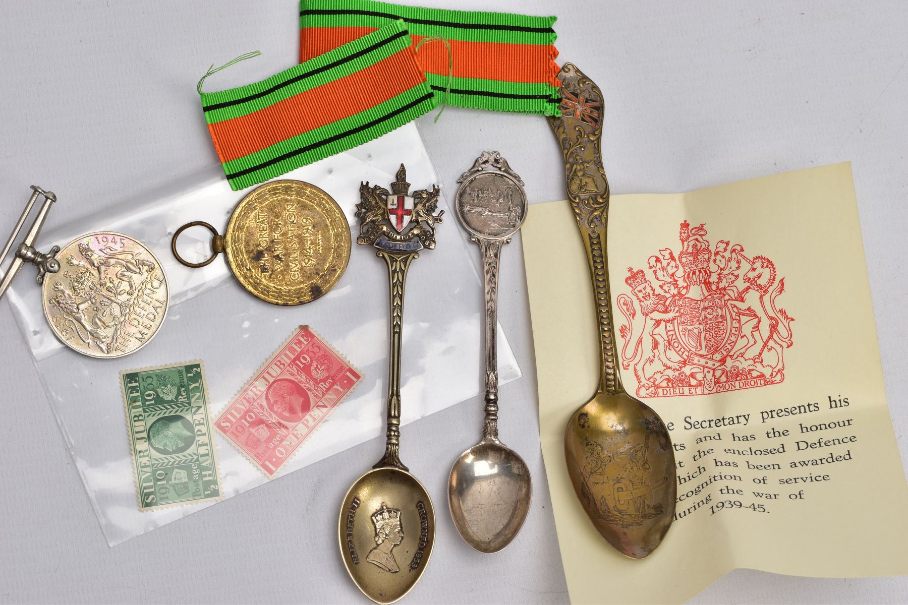 A BAG OF COLLECTABLE SPOONS AND TWO MEDALS, to include a silver teaspoon fitted with an army scene