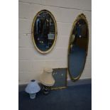 AN OVAL FOLIATE GILT WOOD WALL MIRROR, another gilt mirror and another mirror, along with two