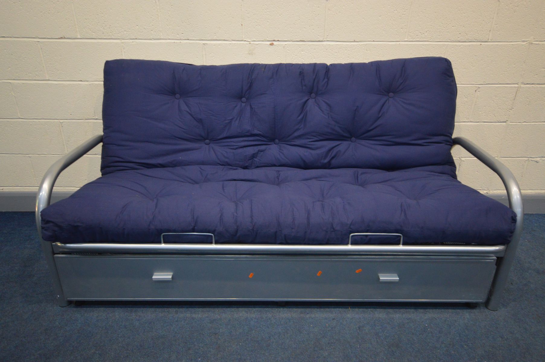 A METAL FRAMED BED SETTEE, with a separate blue cushions and one long drawer