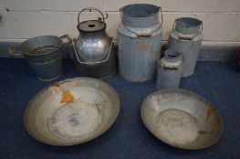 A STAINLESS STEEL MILK CHURN, along with three graduated galvanised milk churns, a galvanised bucket