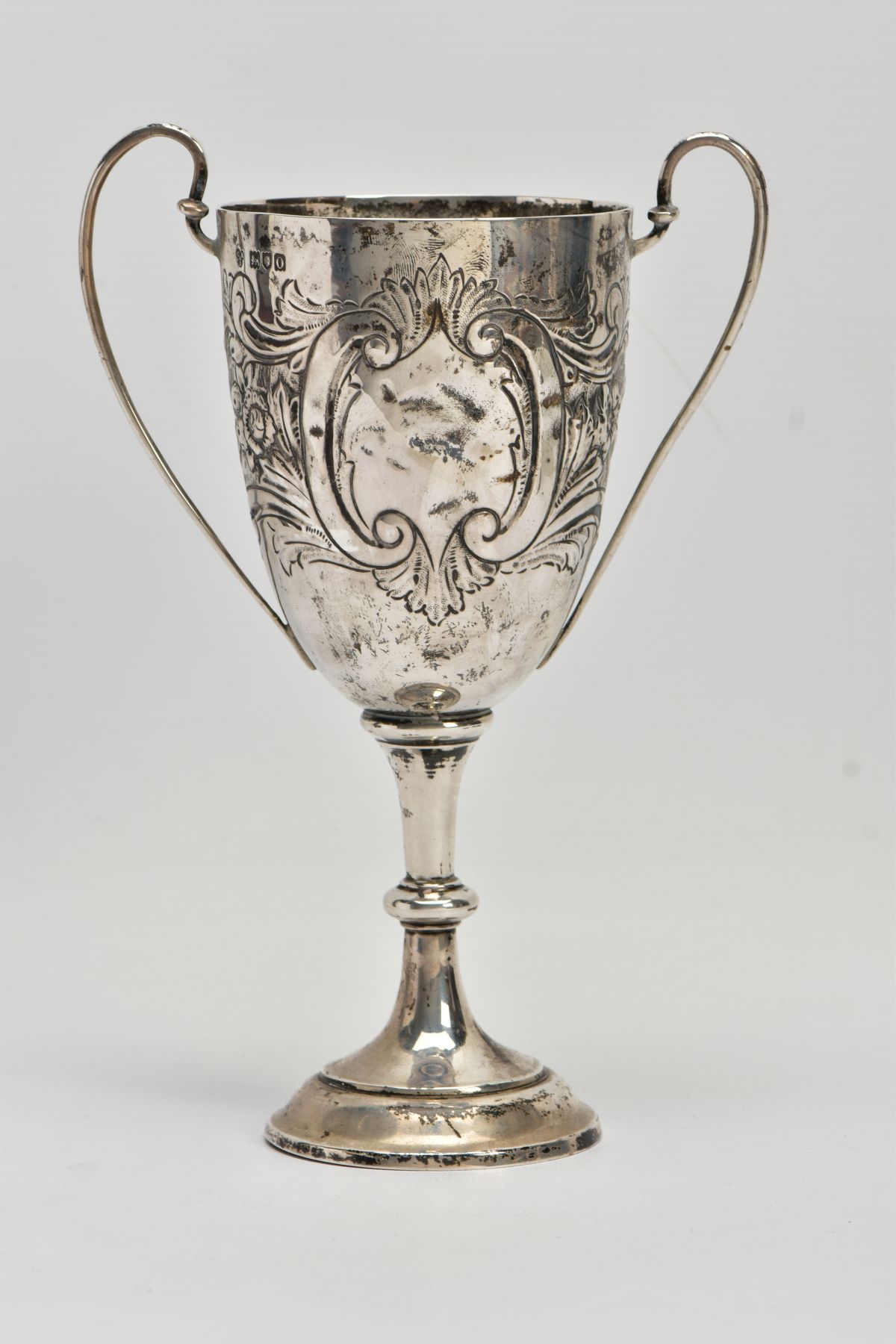 A SILVER TROPHY CUP, double scroll handles, embossed floral and foliate design, with a vacant - Image 3 of 7