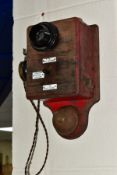A VINTAGE WOODEN WALL TELEPHONE, possibly from a railway signal box, with three enamel plaques to