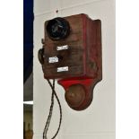 A VINTAGE WOODEN WALL TELEPHONE, possibly from a railway signal box, with three enamel plaques to