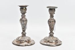 A PAIR OF SILVER CANDLESTICKS, each with a decorative foliate and scroll embossed design, on round