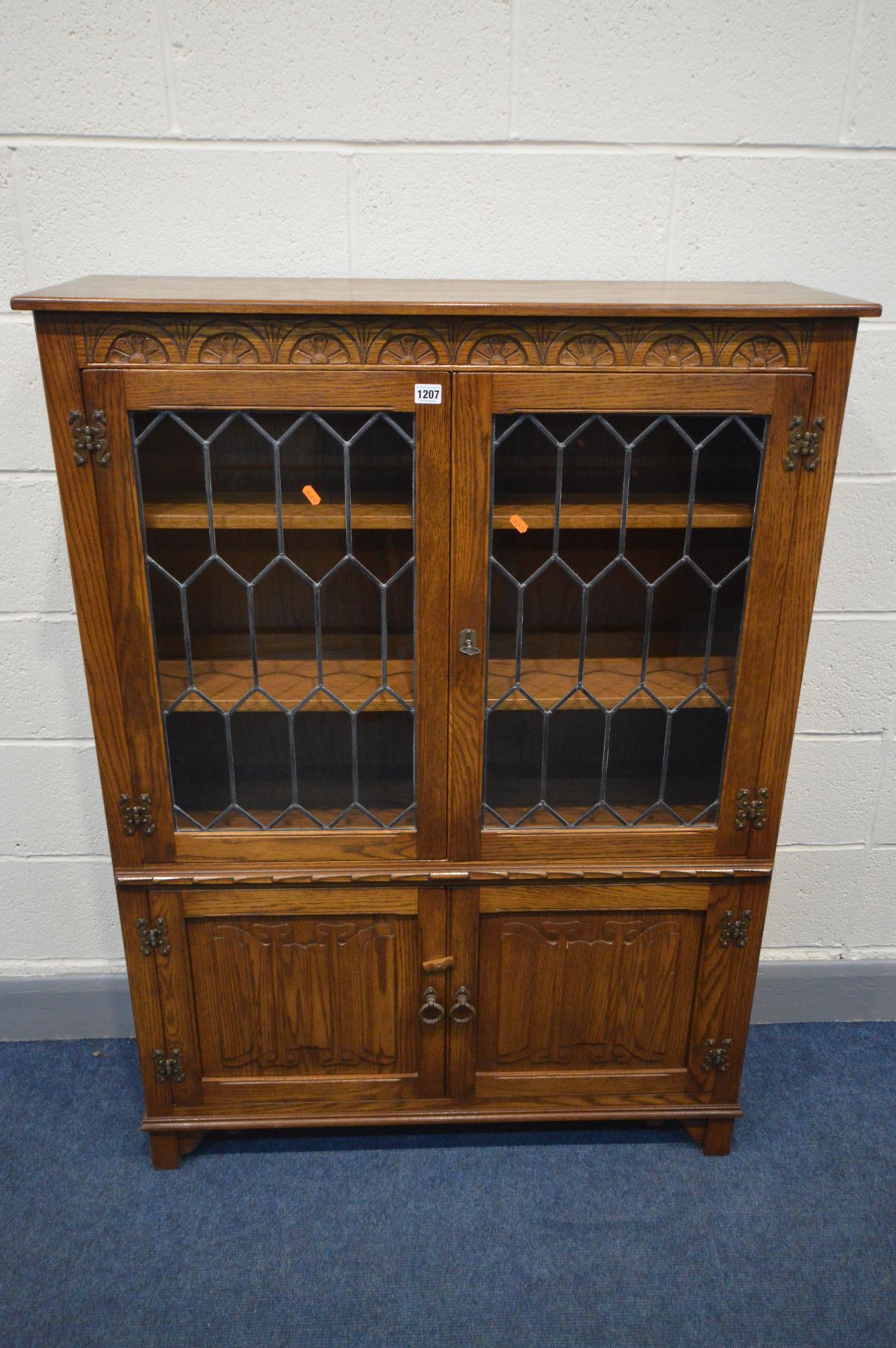 A JAYCEE OAK LEAD GLAZED TWO DOOR BOOKCASE, above double cupboard doors, width 99cm x depth 135cm