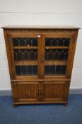 A JAYCEE OAK LEAD GLAZED TWO DOOR BOOKCASE, above double cupboard doors, width 99cm x depth 135cm