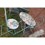 A MODERN FOLDING ROUND GARDEN TABLE AND TWO MATCHING CHAIRS with steel frames, ceramic seats and top
