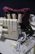 A BERNINA 2000D OVERLOCKING SEWING MACHINE with foot pedal, power cable, a quantity of