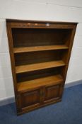 AN OLD CHARM OPEN BOOKCASE, two adjustable shelves above a double door cupboard, width 92cm x