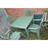 A GREEN PLASTIC GARDEN TABLE 78cm wide and deep 74cm high, four matching chairs and two folding