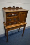 AN EARLY 20TH CENTURY OAK CABINET ON STAND, the cabinet with a shaped raised back, a bank of three