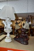 A BRONZED RESIN TABLE LAMP IN THE FORM OF A CHERUB, signed Itassi, twin shades with leaf decoration,