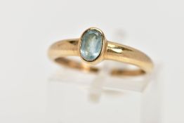 A 9CT GOLD TOPAZ RING, designed as an oval blue topaz within a collet setting, to the plain band,