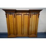 A VICTORIAN OAK INVERTED BREAKFRONT COMPACTUM WARDROBE, overhanging cornice, heavily carved