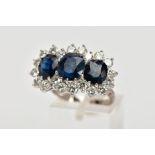 A LARGE SAPPHIRE AND DIAMOND TRIPLE CLUSTER RING. Largest blue sapphire measuring approximately 8.