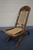 A HARDWOOD ANGLO INDIAN CAMPAIGN CHAIR, with woven seat and back and carving of elephants to top