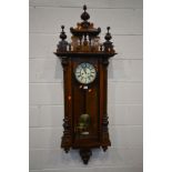 A LATE VICTORIAN WALNUT VIENNA EIGHT DAY WALL CLOCK, decorated pediment, the glazed door enclosing a