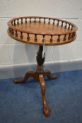 A REPRODUCTION MAHOGANY OCCASIONAL TABLE, with a spindled gallery, to a tripod base, on ball and
