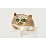 A 9CT GOLD GEM SET RING, in the form of a cat's head, set with circular cut emerald eyes, single cut