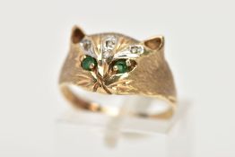 A 9CT GOLD GEM SET RING, in the form of a cat's head, set with circular cut emerald eyes, single cut