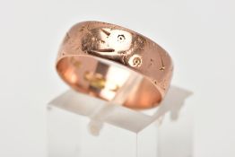 AN EARLY TWENTEITH CENTURY 9CT ROSE GOLD WEDDING RING. Measuring 6.7mm in width, engraved pattern (