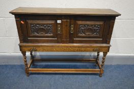 A 20TH CENTURY OAK CREDENCE CABINET, two carved fielded panelled doors above a long slim frieze