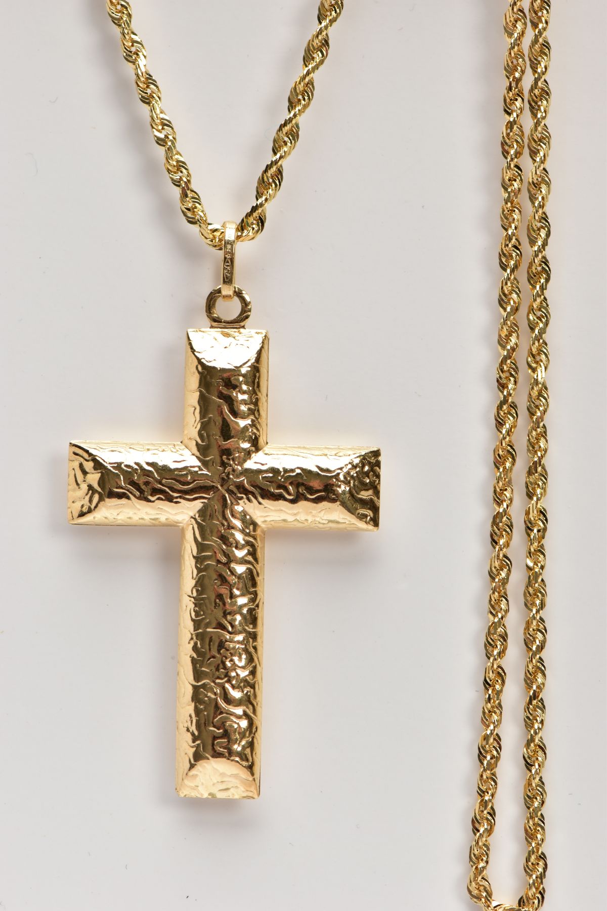 A YELLOW METAL CROSS PENDANT NECKLACE, textured hollow cross pendant, fitted with an oval suspension - Image 2 of 3