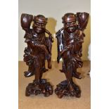 A PAIR OF EARLY 20TH CENTURY CHINESE CARVED HARDWOOD FIGURES OF JOVIAL MEN, with bone teeth, both