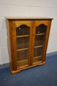 A MODERN PINE GLAZED TWO DOOR BOOKCASE, with triple glass shelves, width 103cm x depth 32cm x height