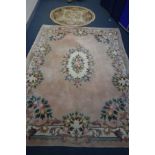 A LARGE PINK WOOLLEN CHINESE CARPET SQUARE, 370cm x 273cm (partially dirty and faded) and a circular