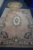 A LARGE PINK WOOLLEN CHINESE CARPET SQUARE, 370cm x 273cm (partially dirty and faded) and a circular