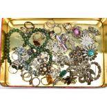 A TIN OF ASSORTED COSTUME JEWELLERY, to include a variety of white metal brooches, a quantity of