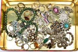 A TIN OF ASSORTED COSTUME JEWELLERY, to include a variety of white metal brooches, a quantity of