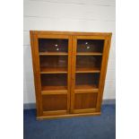 AN OAK GLAZED TWO DOOR BOOKCASE, enclosing three fixed shelves, width 122cm x depth 31cm x height