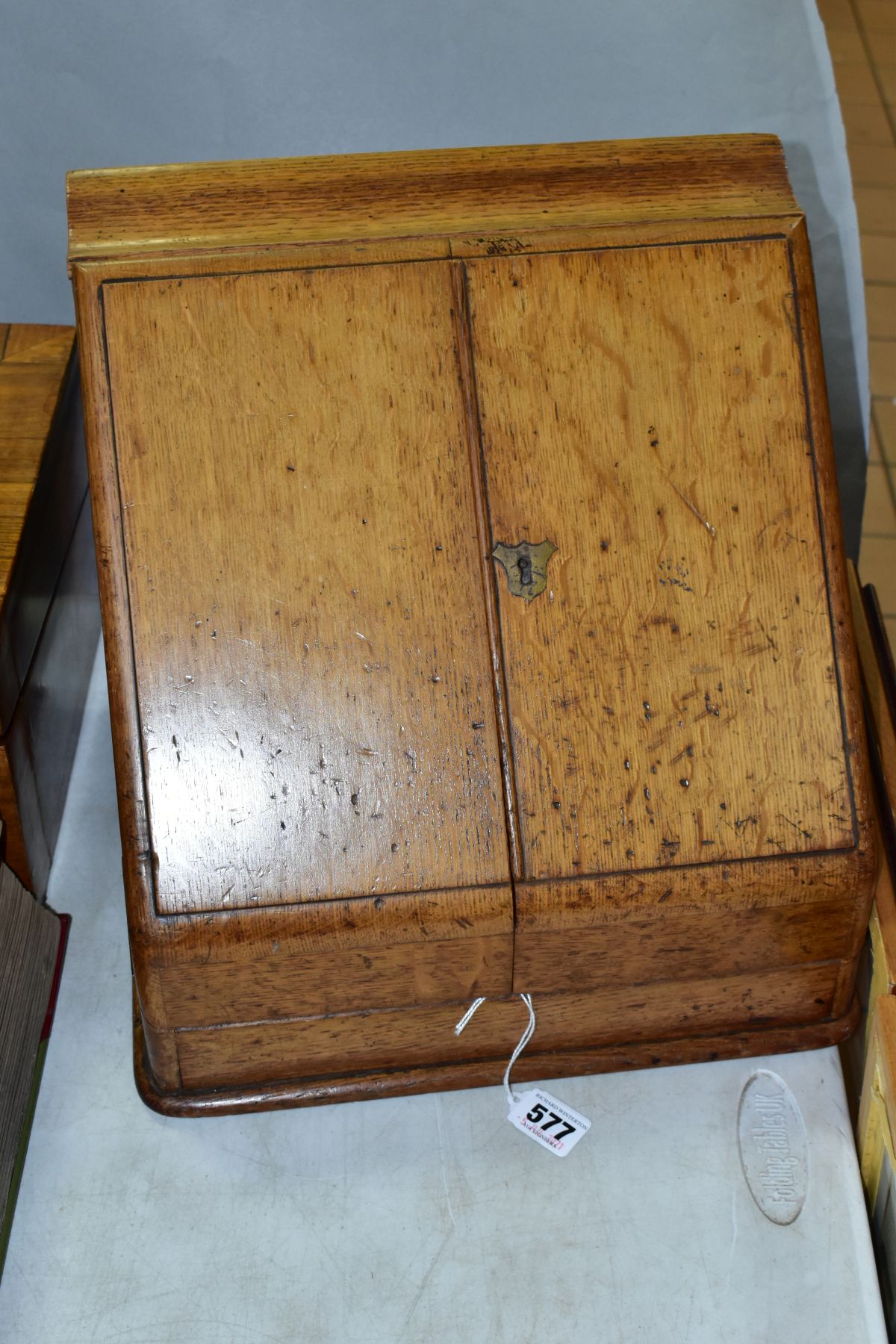 AN EDWARDIAN OAK STATIONERY BOX, hinged top above sloped double doors opening to reveal a fitted