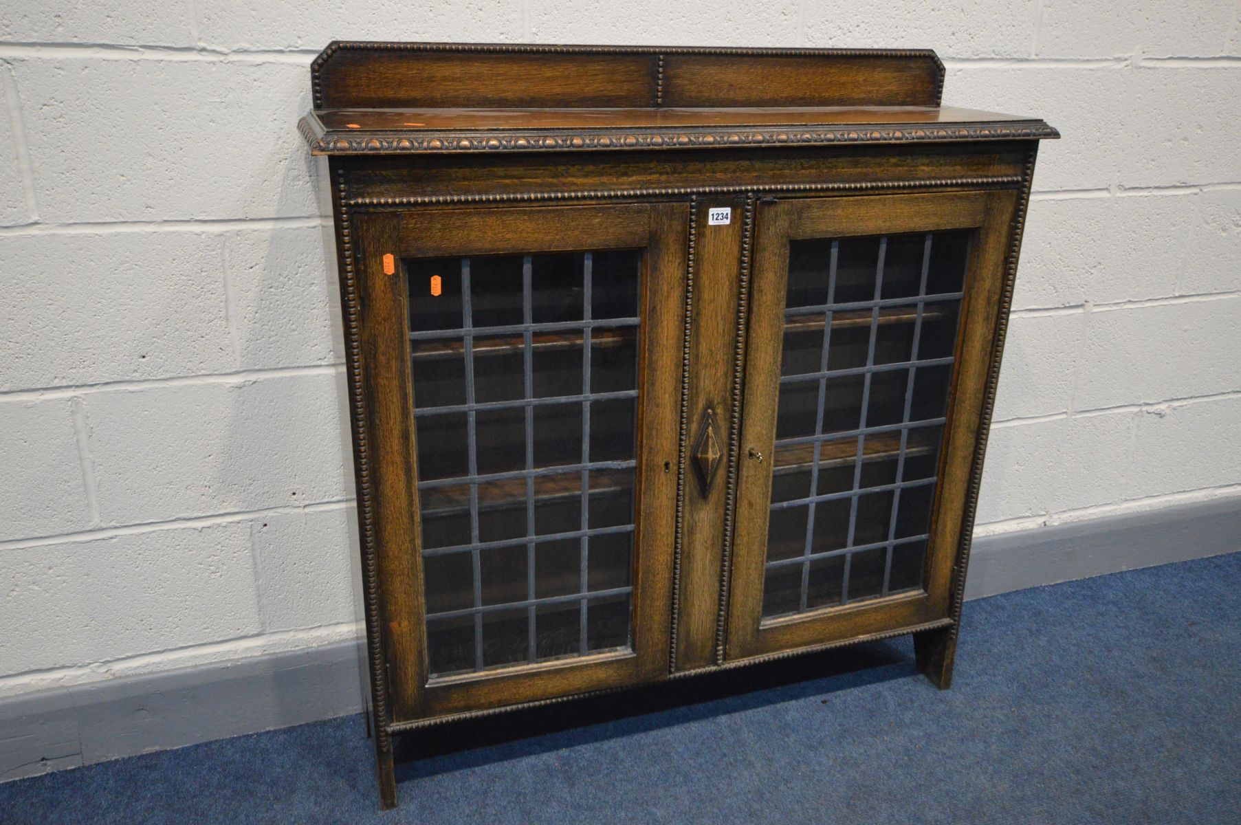 AN EARLY 20TH CENTURY OAK BOOKCASE, a raised back, lead glazed double doors enclosing two adjustable - Image 2 of 2