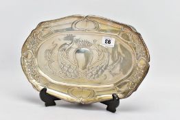 AN EDWARDIAN SILVER TRAY, oval form, embossed peacock and floral design, with a central shield