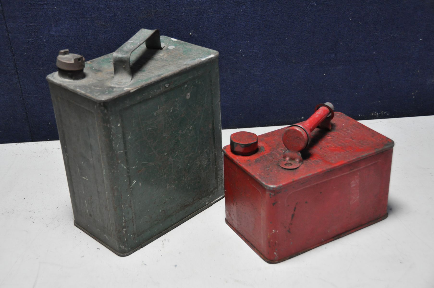 TWO VINTAGE PETROL CANS comprising of one at 32cm high with a brass screw cap and the other 20cm