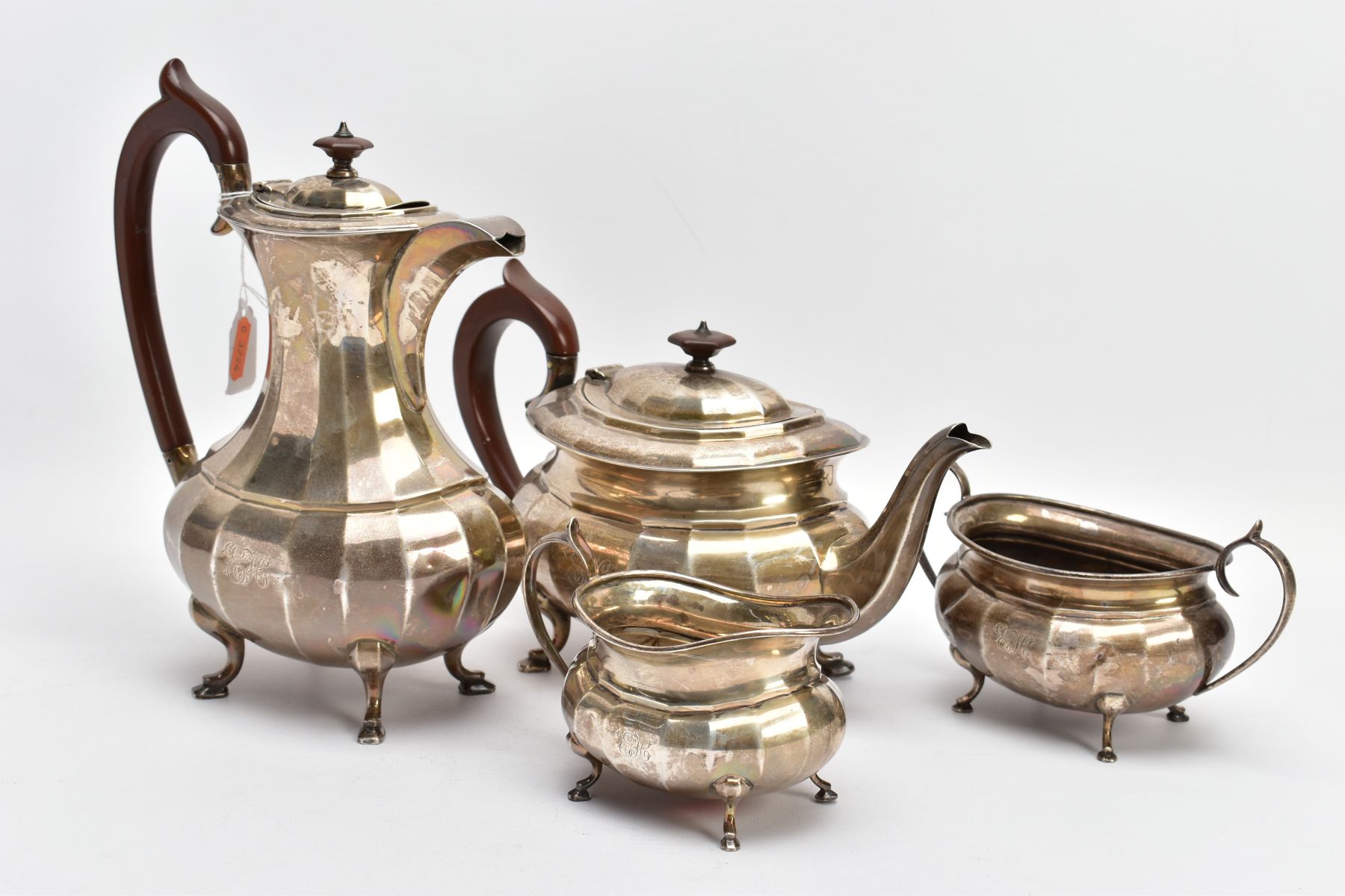 A FOUR PIECE GEORGE.V SILVER TEA SET, to include a teapot and hot water jug each of a faceted George