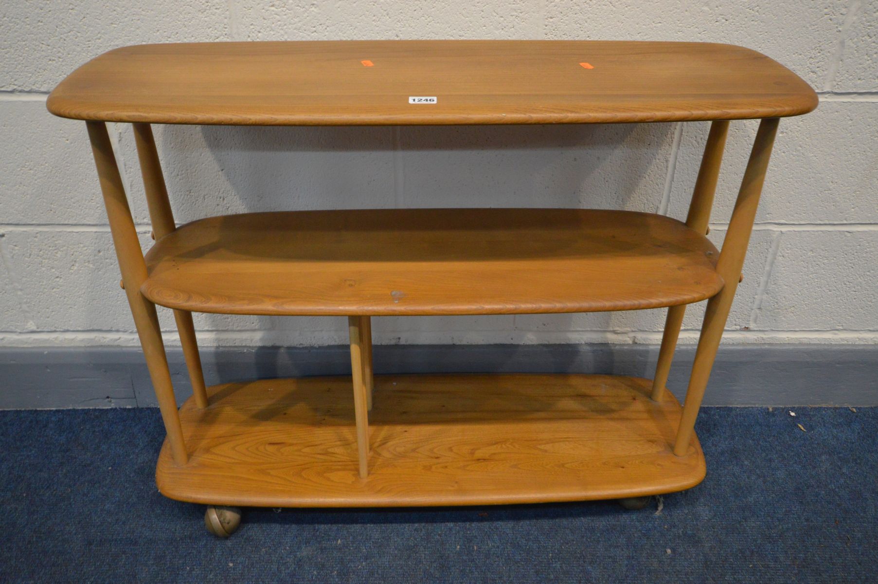 AN ERCOL ELM AND BEECH MODEL 361 WINDSOR THREE TIER TROLLEY BOOKCASE, on casters, width 92cm x depth