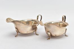 A PAIR OF SILVER SAUCE BOATS, with a plain design and cut rim, each sitting on three raised feet,