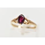 A 9CT GOLD GARNET RING, the oval garnet within a six-claw setting, to the bifurcated shoulders,