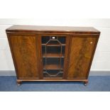 A MAHOGANY THREE DOOR BOOKCASE, with a central glazed compartment, enclosing adjustable shelves,